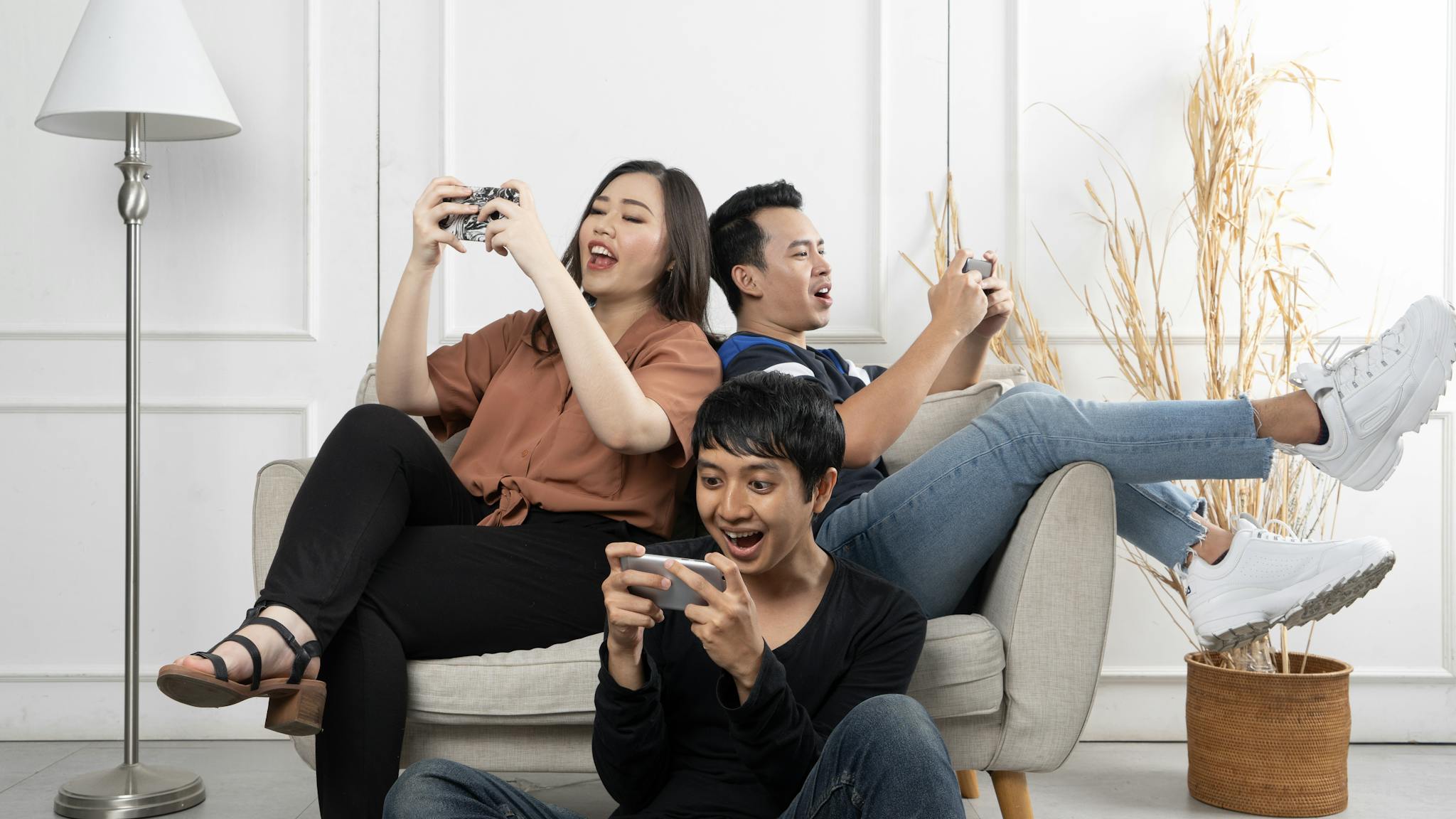 Three friends enthusiastically playing video games indoors, having fun and relaxing.